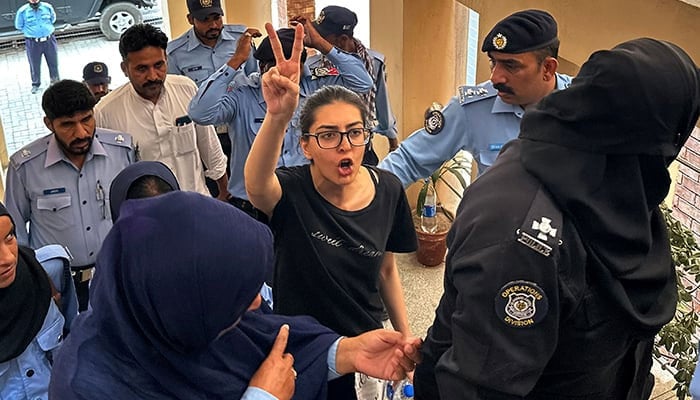 Police officials present arrested lawyer and human rights activist Imaan Mazari-Hazir (centre) before a court in Islamabad on August 20, 2023. — AFP