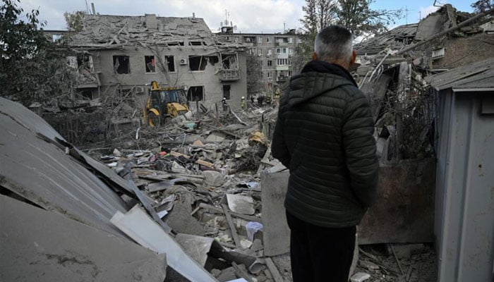 A man stands in front of a wreckage in Ukraine in this undated image. — AFP/file