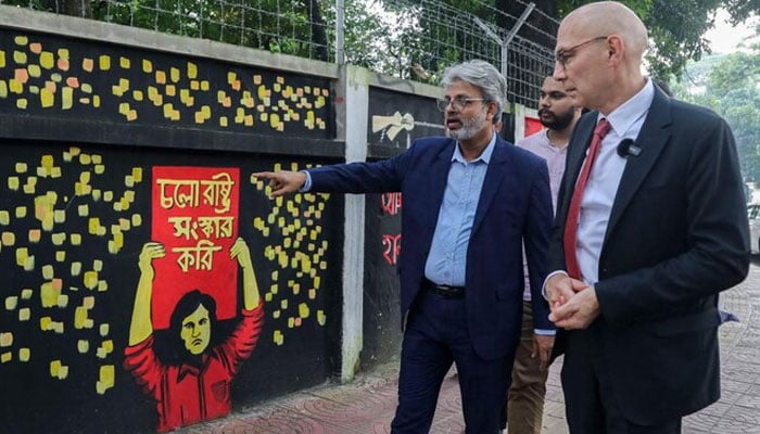 United Nations High Commissioner for Human Rights Volker Turk, right, looks at graffiti on the walls of Dhaka university campus in Dhaka on Oct. 29, 2024.— AFP