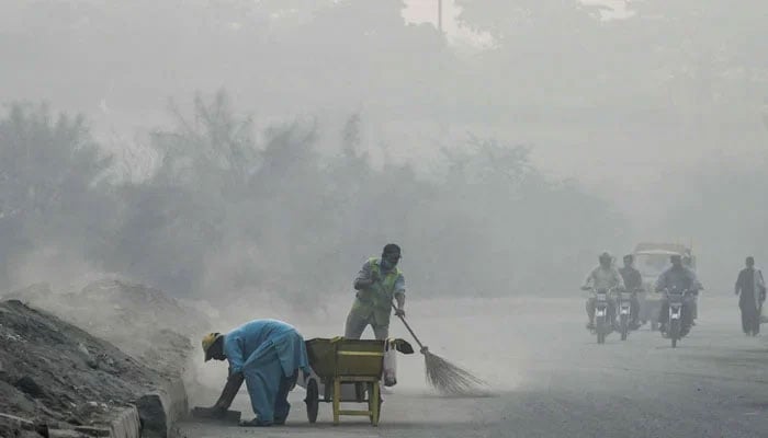 Motorists on their way during heavy smog in morning hours in Lahore on November 30, 2022. — Online