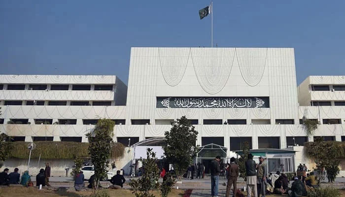 The representational image shows security and media officials gather in front of the Parliament House building in Islamabad. — AFP/File