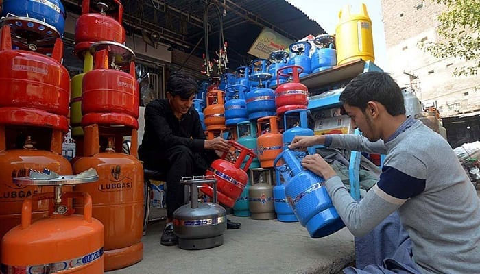 Gas cylinder vendors working at a shop. — APP/File