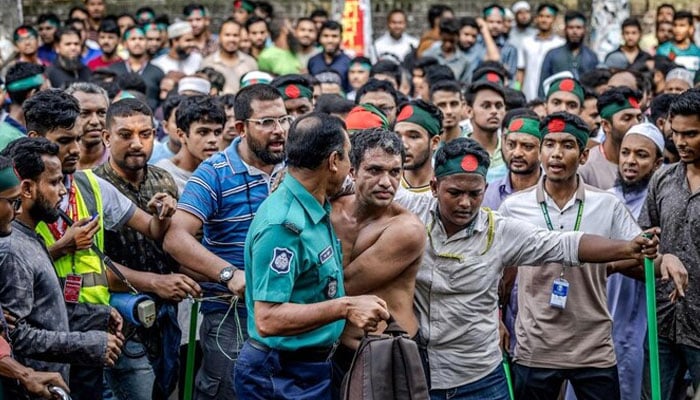 Protesters surround a suspected sympathizer of ousted ex-premier Sheikh Hasina, near the house of her father Sheikh Mujibur Rahman, the first president of independent Bangladesh, in Dhaka on August 15, 2024. — AFP