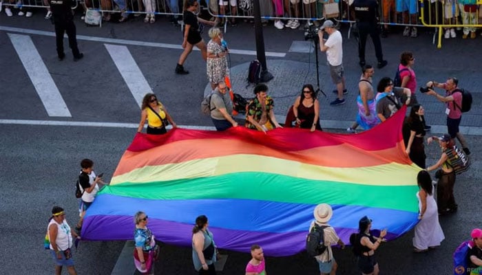 People carry a rainbow flag, as they take part in the annual LGBT Pride Parade in Madrid, Spain Jul 6, 2024. — Reuters