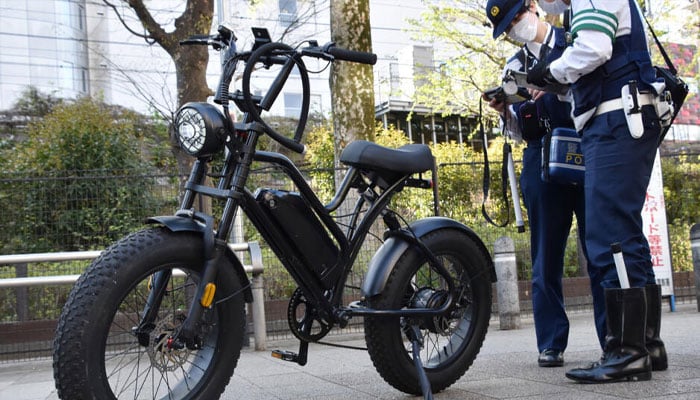 An image of a bike with police officers standing behind it. — AFP/file