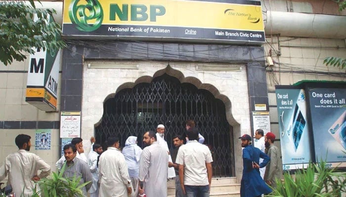 This image shows citizens lined up outside the National Bank of Pakistan. — APP/File