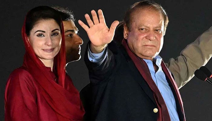 Former prime minister Nawaz Sharif (right) stands beside his daughter and Punjab CM Maryam Nawaz (left) as he waves to his supporters gathered at a park during an event held to welcome him in Lahore on October 21, 2023. —AFP