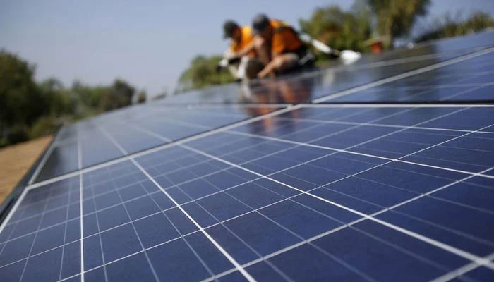 Solar technicians installing the solar panels on the roof of a house. — Reuters/File