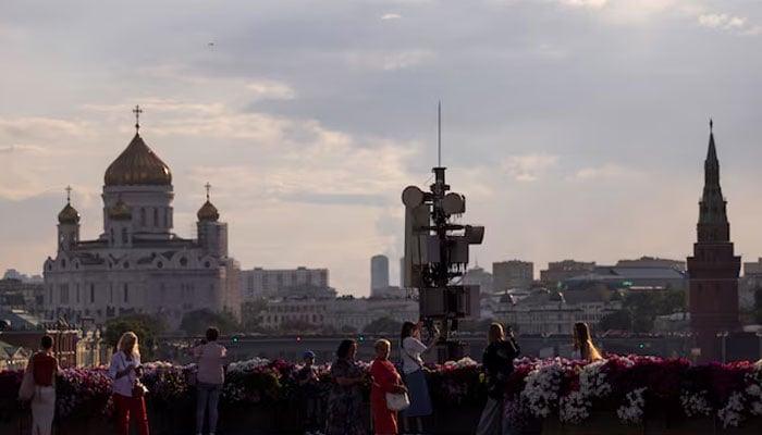 People gather on a bridge with the view on Christ the Savior Cathedral, towers of the Kremlin and city’s skyline in Moscow, Russia on August 5, 2024. — Reuters