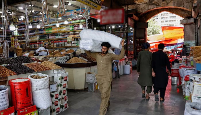 Representational image shows a man walks with sacks of supplies on his shoulder to deliver to a nearby shop at a market on June 11, 2024. — Reuters