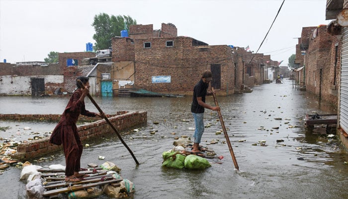 Men paddle on makeshift rafts as they cross a flooded street, amidst rainfall during the monsoon season in Hyderabad, Pakistan August 24, 2022. — Reuters