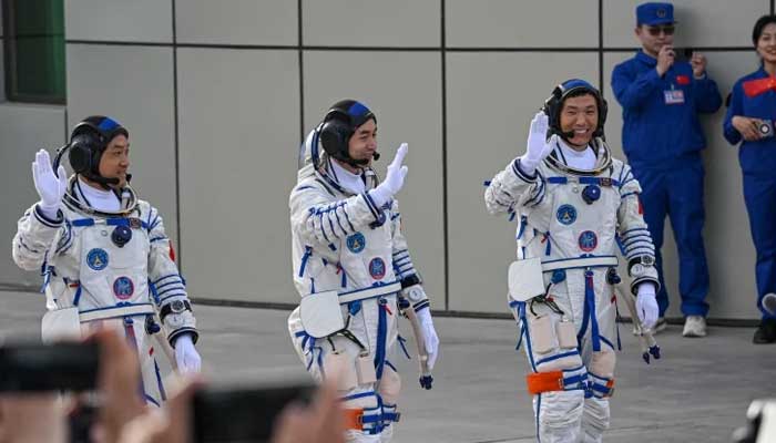 Astronauts for Chinas Shenzhou-18 space mission (L-R) Li Guangsu, Ye Guangfu and Li Cong wave during a departure ceremony before boarding a bus to take them to the Shenzhou-18 spacecraft at the Jiuquan Satellite Launch Centre in the Gobi desert in northwest China on April 25, 2024. — AFP