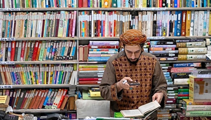 A student taking pictures of an Urdu book at the Hazrat Shah Waliullah public library, in Urdu Bazar in the old quarters of Delhi on October 22, 2024. —AFP