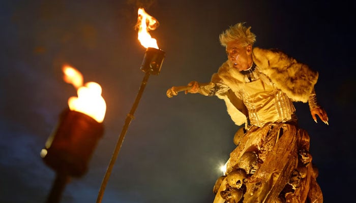 A member of street performance troupe Macnas performs while holding a sphere of light in his mouth during a Halloween parade called Cnamha La Loba in Galway, Ireland. — Reuters/File