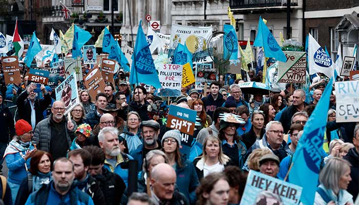 People hold placards as they take part in a March for Clean Water in London on November 3, 2024. — AFP