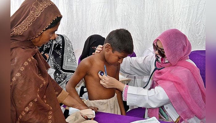 Representational image shows a lady Doctor examines a child in a medical camp. — APP/File