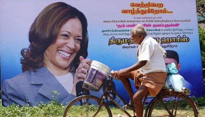 A man rides his bicycle past a banner of US Vice President Kamala Harris installed alongside a road in the village of Thulasendrapuram, where Harriss maternal grandfather was born more than a century ago, in the southern state of Tamil Nadu, India on July 27, 2024.— Reuters