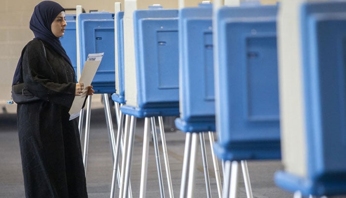 A female voter cast her ballot during Michigans early voting period on October 29, 2024 in Dearborn, Michigan. — AFP