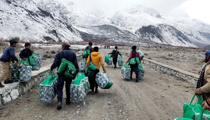 In this image (KSrelief) volunteers carrying bags. — APP/File