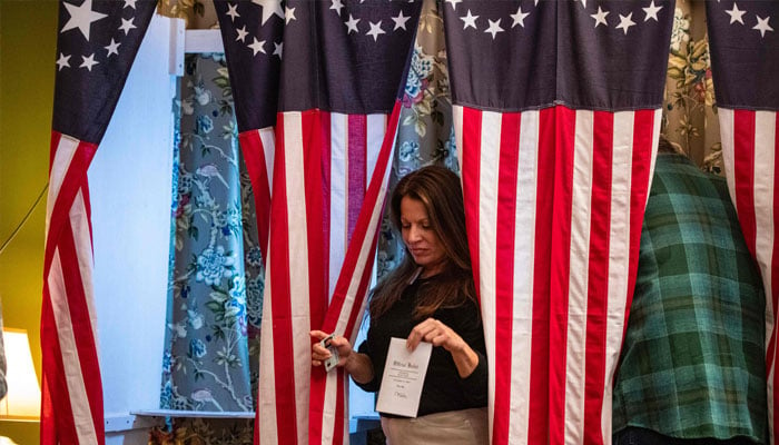 Residents of Dixville Notch cast their ballots in the US election at midnight in the living room of the Tillotson House at the Balsams Grand Resort, marking the first votes in the US election, in Dixville Notch, New Hampshire on November 5, 2024. — AFP