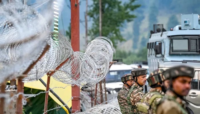 Indian soldiers standing near a barbed fence.— AFP/file