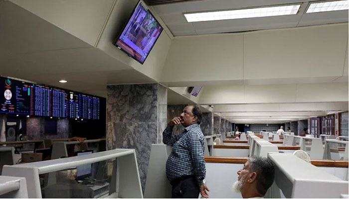 Stock brokers monitor news on television screen at a booth, during a trading session at the Pakistan Stock Exchange, in Karachi, on July 3, 2023. — Reuters