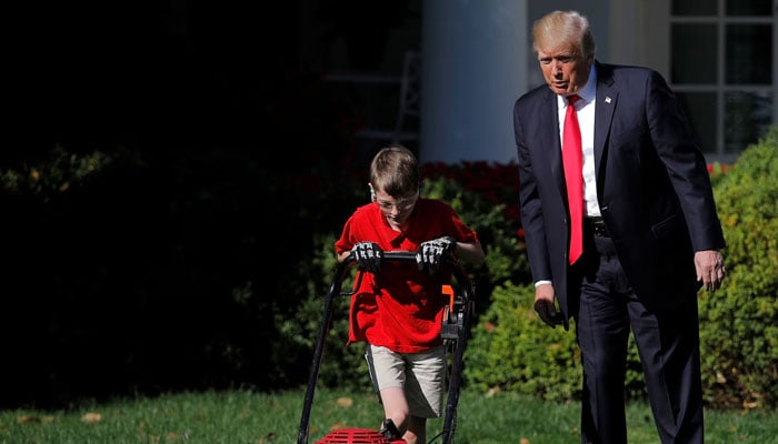 President Trump looks on as 11-year-old Frank Giaccio cuts the Rose Garden grass.— Reuters/File