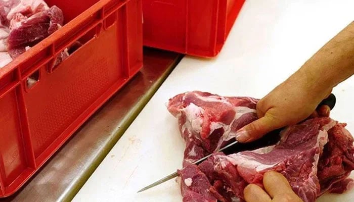 This representational Image shows a person cutting meat. — AFP/File