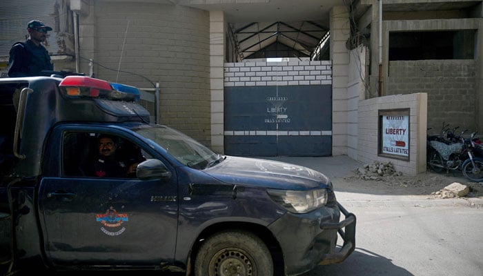 Police personnel stand guard outside a factory where two Chinese nationals were allegedly shot, in Karachi on November 5, 2024. — AFP