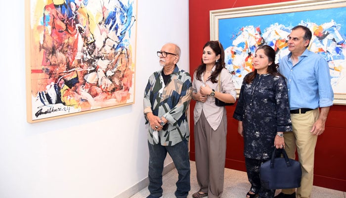 Visitors take a keen interest in a painting during a painting exhibition by Mashkoor Raza at Frame Art Gallery in Karachi on November 6, 2024. — Online