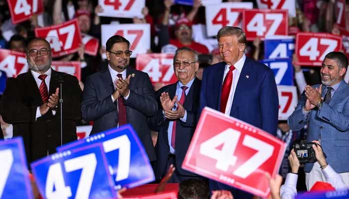 US President-elect Donald Trump stands with local leaders of the Muslim community as they endorsed him onstage during a campaign rally at the Suburban Collection Showplace in Michigan. — AFP/File