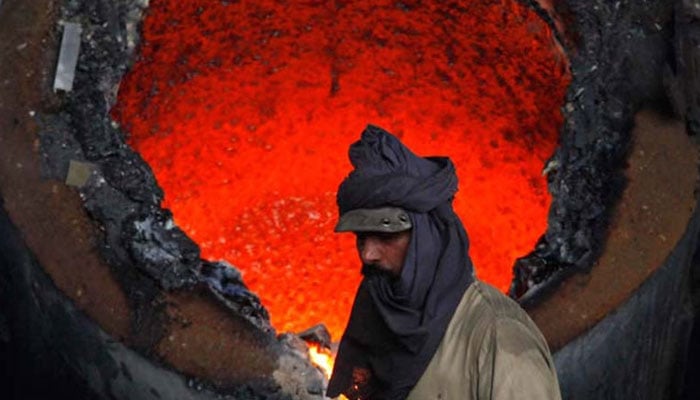 A worker standing near an iron melting burner. — Reuters/File