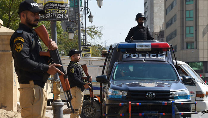 Police personnel stand guard on a street in Karachi. — AFP/File