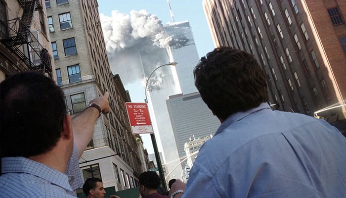 Pedestrians react to the World Trade Center collapse on September 11, 2001. — Reuters