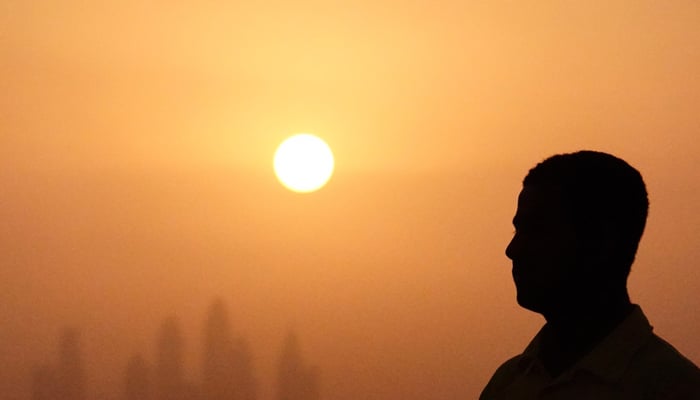 A lifeguard stands near a swimming pool while the sun sets over Dubai, United Arab Emirates, August 12, 2023. — Reuters