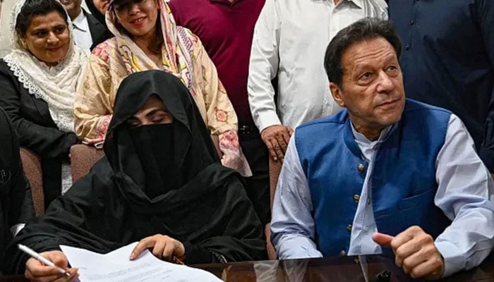 PTI founder Imran Khan and his wife, Bushra Bibi ahead of a court hearing. — AFP/File