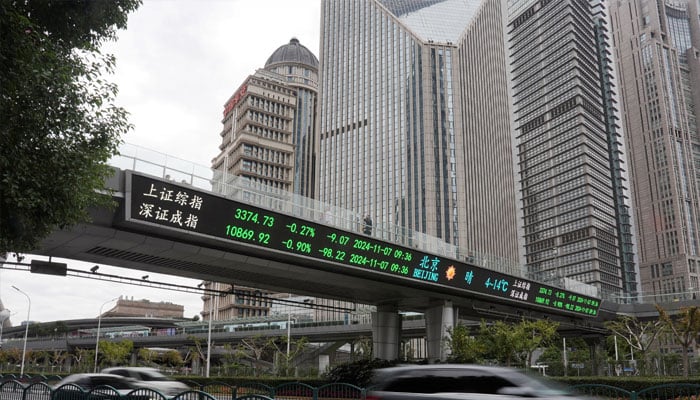 Cars travel past a pedestrian overpass with a display of stock information at the Lujiazui financial district in Shanghai, China, November 7, 2024. — Reuters