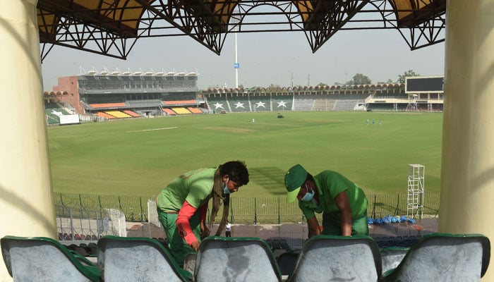 Ground workers clean the Gaddafi Stadium in Lahore. — AFP/file