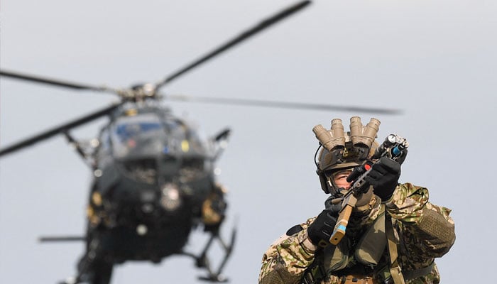 A German military member takes position, while a helicopter flies, at a German naval forces training site, in Eckernfoerde, Germany, February 21, 2023. — Reuters