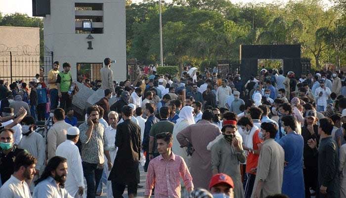 A mob gathers in front of the main entrance of Pakistan Armys General Headquarters (GHQ) during a protest against the arrest of PTI founder Imran Khan in Rawalpindi on May 9, 2023. — AFP