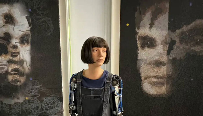 Humanoid robot Ai-Da (center) is pictured with her painting of renowned English mathematician Alan Turing. — Reuters/file