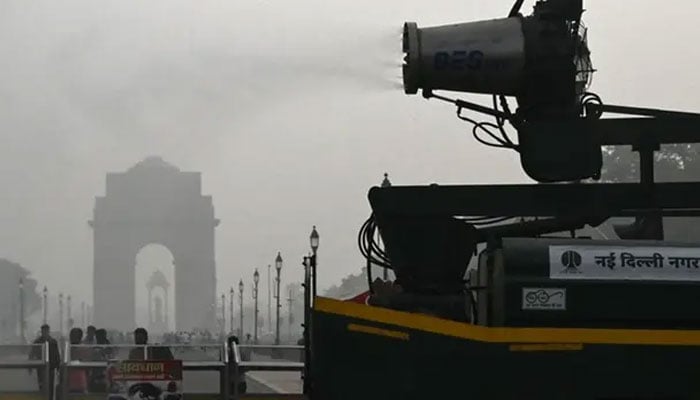 A vehicle of the Public Works Department (PWD) sprays water using an anti-smog gun to curb air pollution amid heavy smoggy conditions near the India Gate in New Delhi on November 7, 2024. — AFP