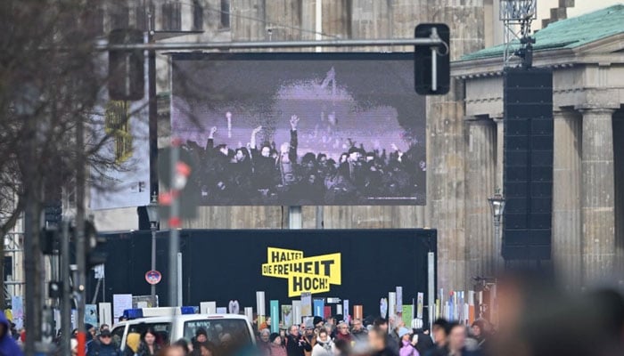 A screen displays footage of 1989 at the Brandenburg gate over a slogan reading Keep up the freedom ahead of celebrations marking the 35th anniversary of the fall of the Berlin Wall in Berlin on November 9, 2024. — AFP