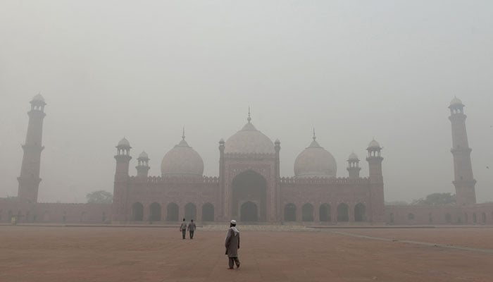 People visit Badshahi Mosque amid heavy smoggy conditions in Lahore on November 9, 2024. — AFP