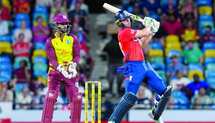 Jos Buttler (right) of England hits six to bring up his fifty and Nicholas Pooran (left) of West Indies watches during the second T20 International match between West Indies and England at Kensington Oval in Bridgestown, Barbados, on November 10, 2024. — AFP