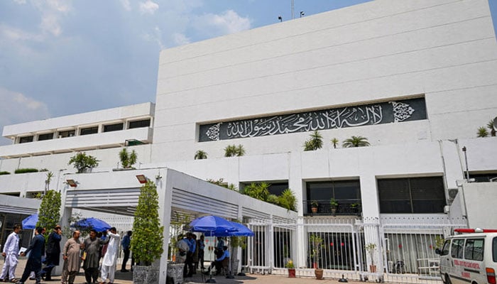 People stand outside the Parliament house in Islamabad on June 26, 2024. — AFP