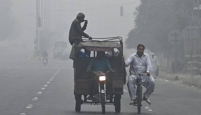 Commuters ride along a road engulfed in thick smog in Lahore on November 11, 2024. Lahore, a city of 14 million people stuffed with factories on the border with India, regularly ranks among the world´s most polluted cities, but it has hit record levels this month. — AFP