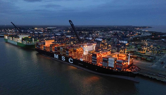 An aerial picture shows stacks of containers pictured on the deck of the MSC Allegra (right) and Ever Atop (left) container ships, docked beside container cranes at a port. — AFP/file