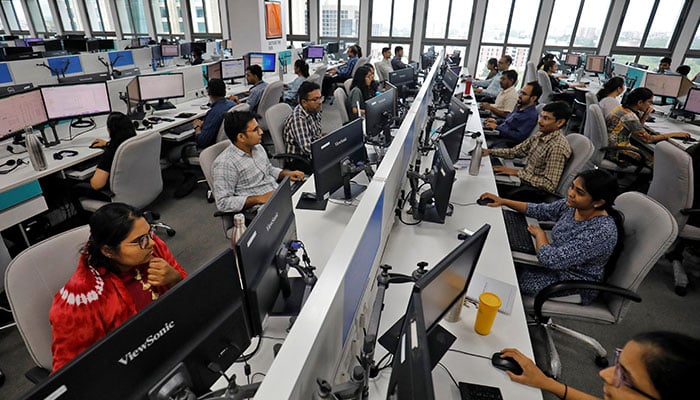 Employees work on their terminals inside an office. — Reuters/File