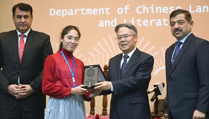 Ambassador of China Jiang Zaidong (2nd right), gives a shield to the winner of the Chinese Speech Contest 2024 at National University of Modern Languages (NUML) in Islamabad on November 13, 2024. — APP